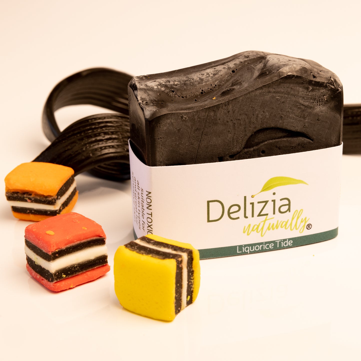 Coconut and Aniseed Bar of soap with 'Delizia' branding and colorful candy-like bars on a white background