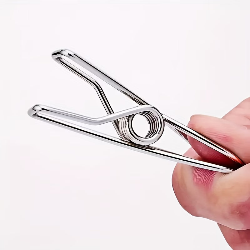 stainless steel clothes peg held by a hand on a white background